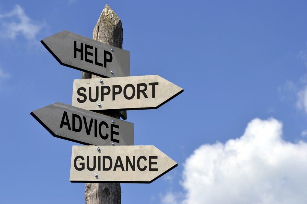 A wooden picket sign with signs for help, support, advice, and guidance