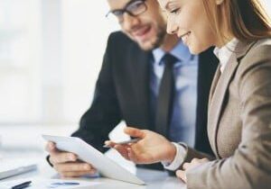 Young businesswoman explaining report to her colleague at meeting